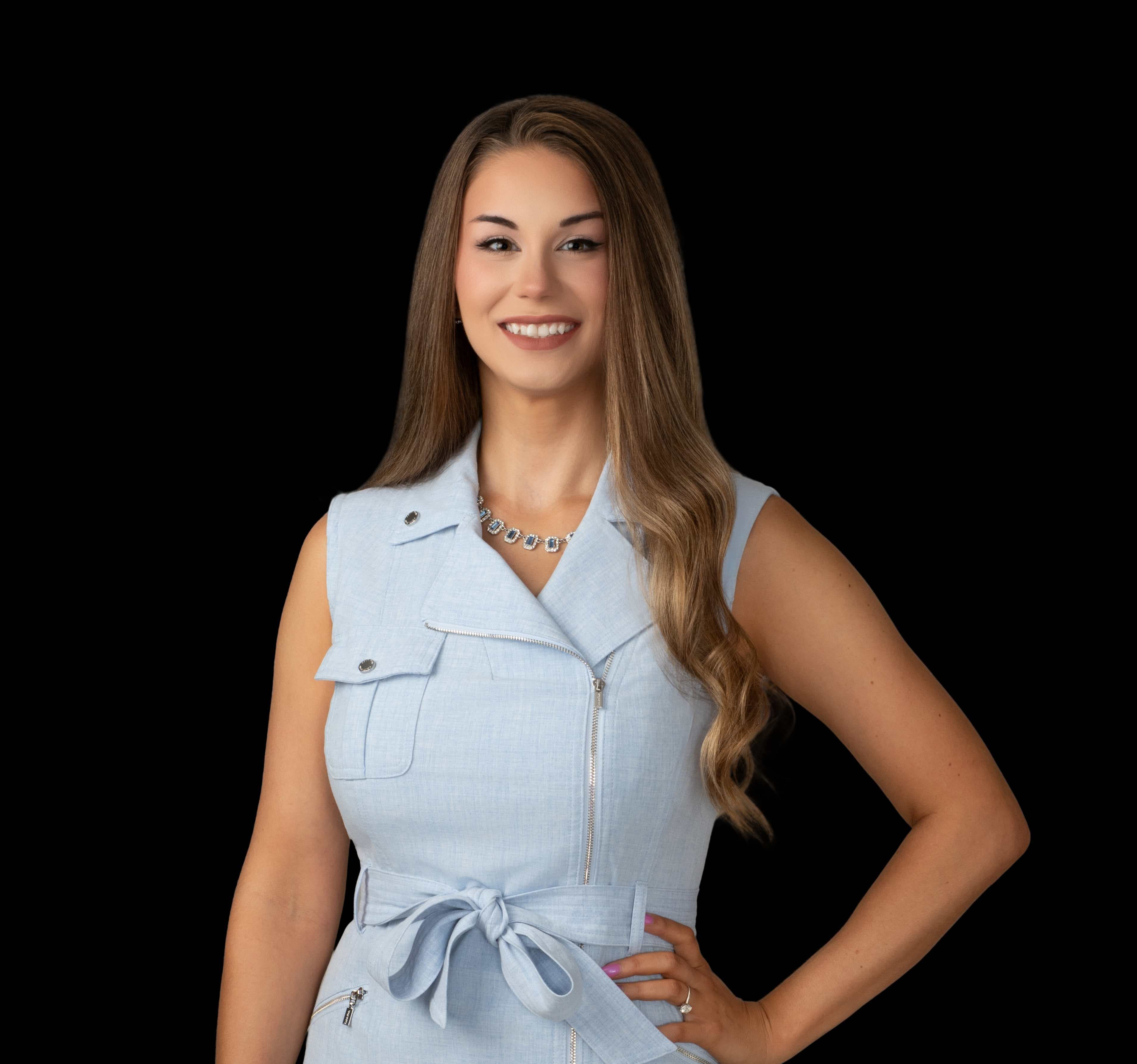 Portrait of Lindsey Howell, publisher of Stroll St. Pete, smiling in a light blue sleeveless dress